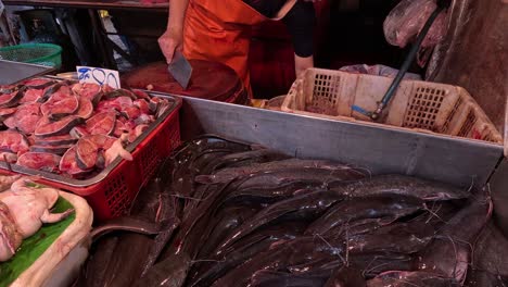 vendor arranging seafood at a busy market stall