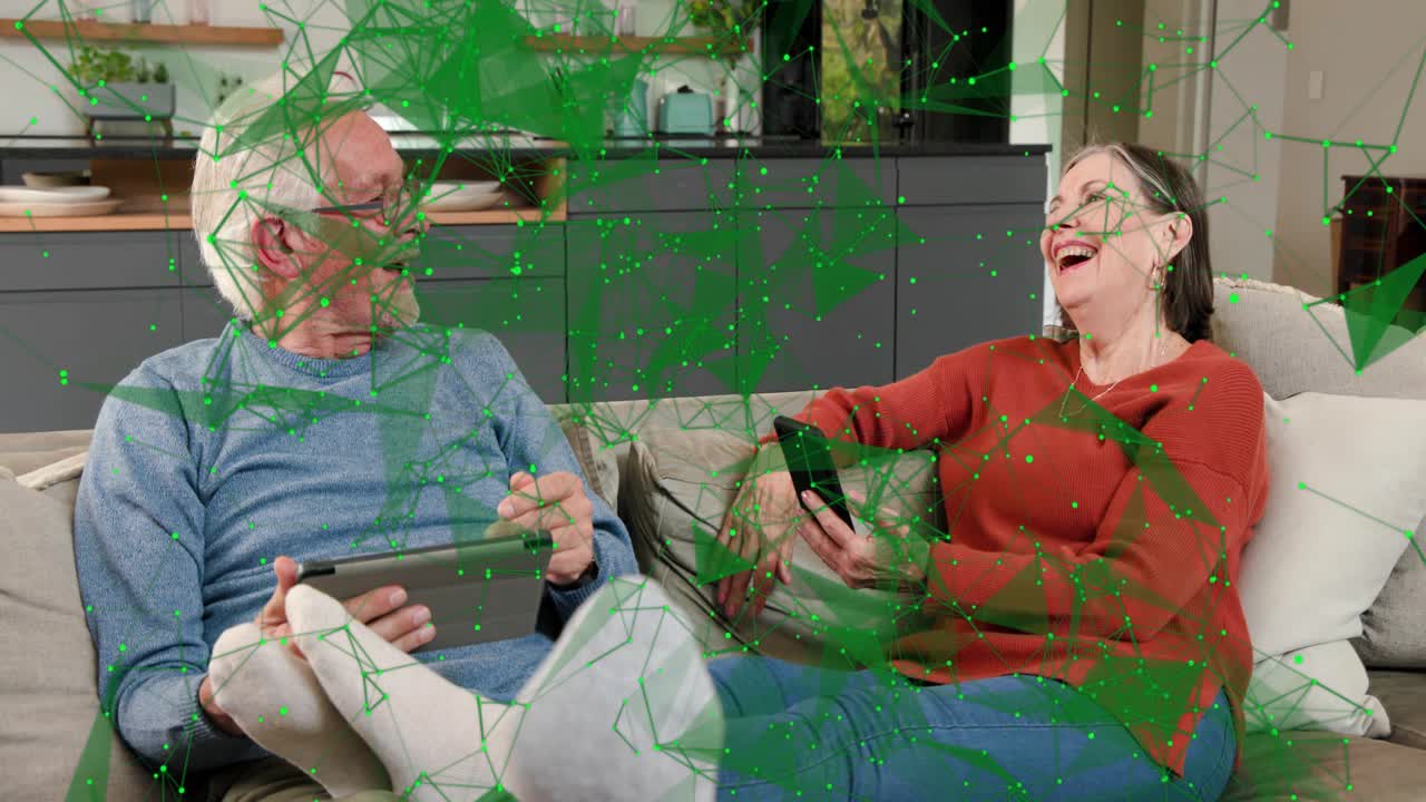 Uomo anziano che si collega dopo che il partner ha toccato il tablet, guardando in su e ridendo, sovrapposizione verde che si connette alla coppia