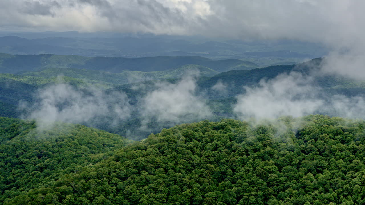 Long drone shot over distant Smoky ridges wrapped in rain and mist