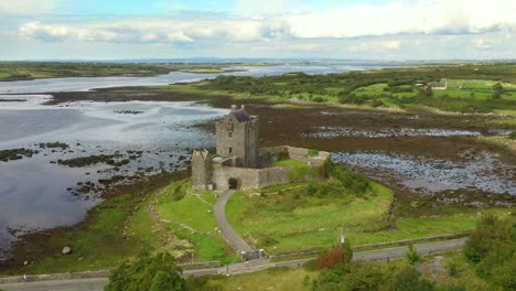 castillo de dunguaire, kinvara, galway, irlanda, agosto de 2020, el dron orbita lentamente el castillo pasando por la vista de la bahía de galway revelando el pueblo de kinvara en el fondo