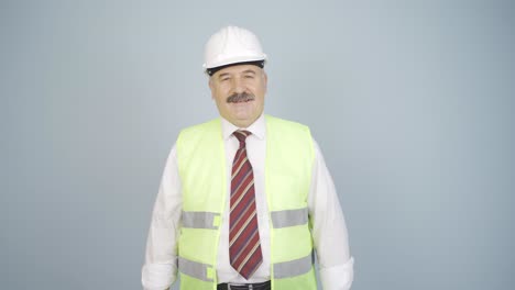 el ingeniero con un casco y sonriendo.