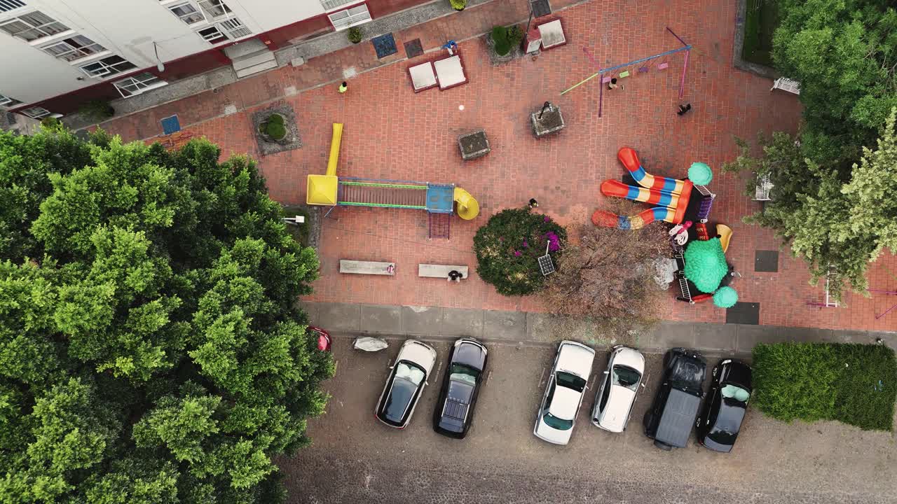 Vista aerea al rallentatore di bambini che giocano a palla in un parco giochi.
