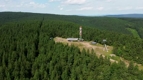 Drone-view-during-which-it-rotates-around-the-sky-resort-above-a-forest-full-of-trees