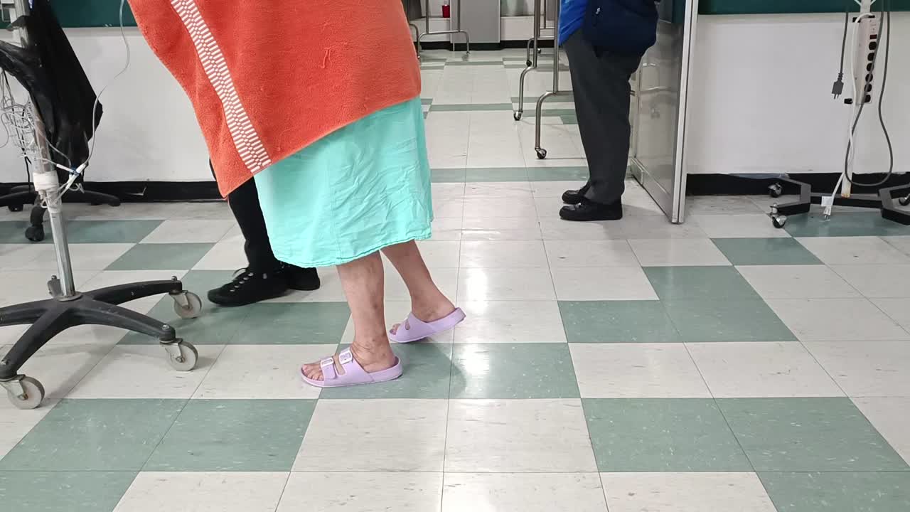 Woman assisting an elderly woman with a walker in hospital. Slow motion