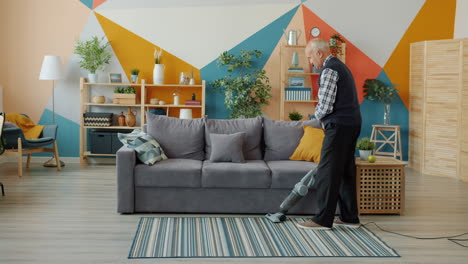 older man vacuuming living room