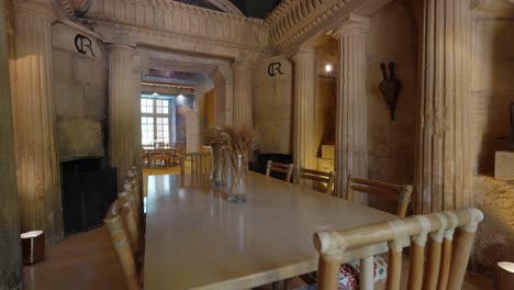 Langsam-Umlaufende-Aufnahme,-Die-Einen-Speisesaal-Mit-Römischen-Säulen-Im-Chateau-De-Castille-Zeigt