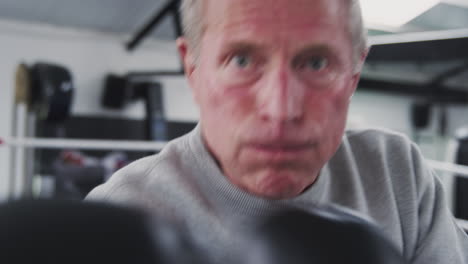 vista desde el punto de vista del entrenador de boxeo masculino senior en el gimnasio luchando en el ring de boxes