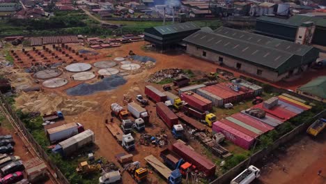 jib down of a large industrial zone with factories and a building under construction ibadan, nigeria on a sunny day