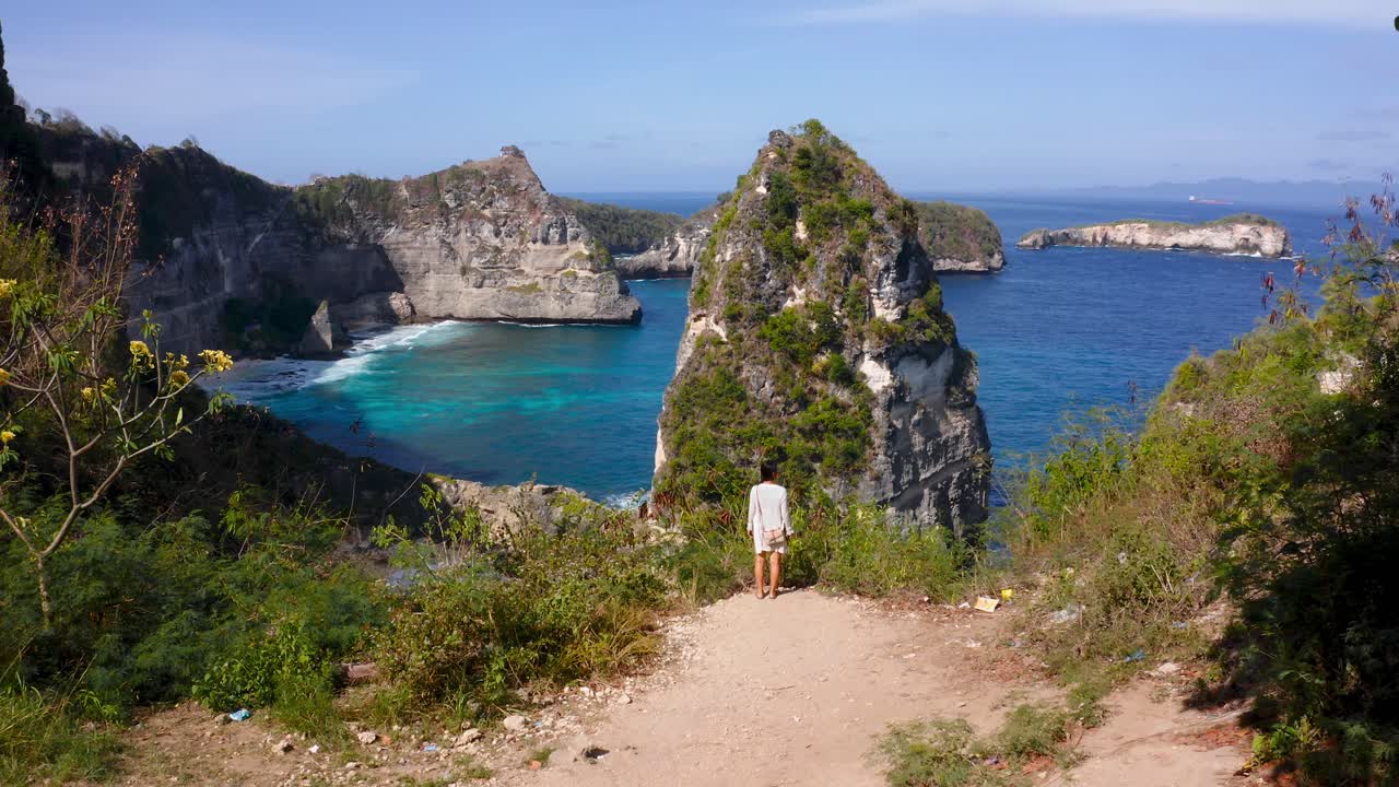 mujer viajera caminando en el mirador de la isla de nusa penida con vistas a los acantilados costeros