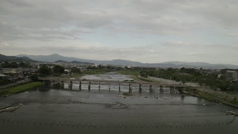 Aerial-Drone-Shot-of-Kyoto-at-Sunset-near-a-river,-Japan,-Asia