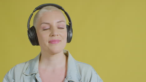 modelo caucásico femenino escuchando música con auriculares retrato de estudio 02