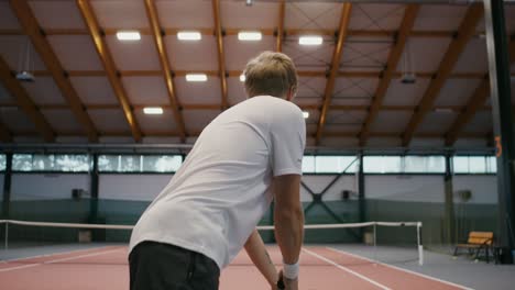 man playing tennis indoor