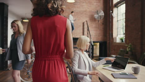 Mixed-race-business-woman-walking-through-busy-office