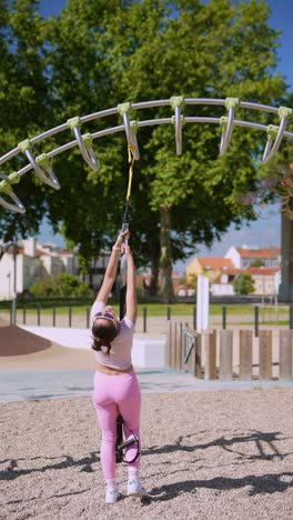 woman exercising outdoors on suspension training equipment