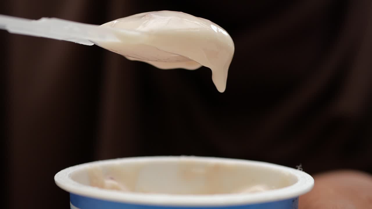 persona comiendo yogur de una taza