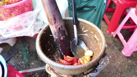 preparing spicy papaya salad in a mortar