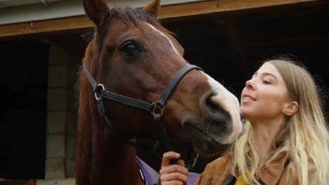mujer besando a un caballo en el establo 4k