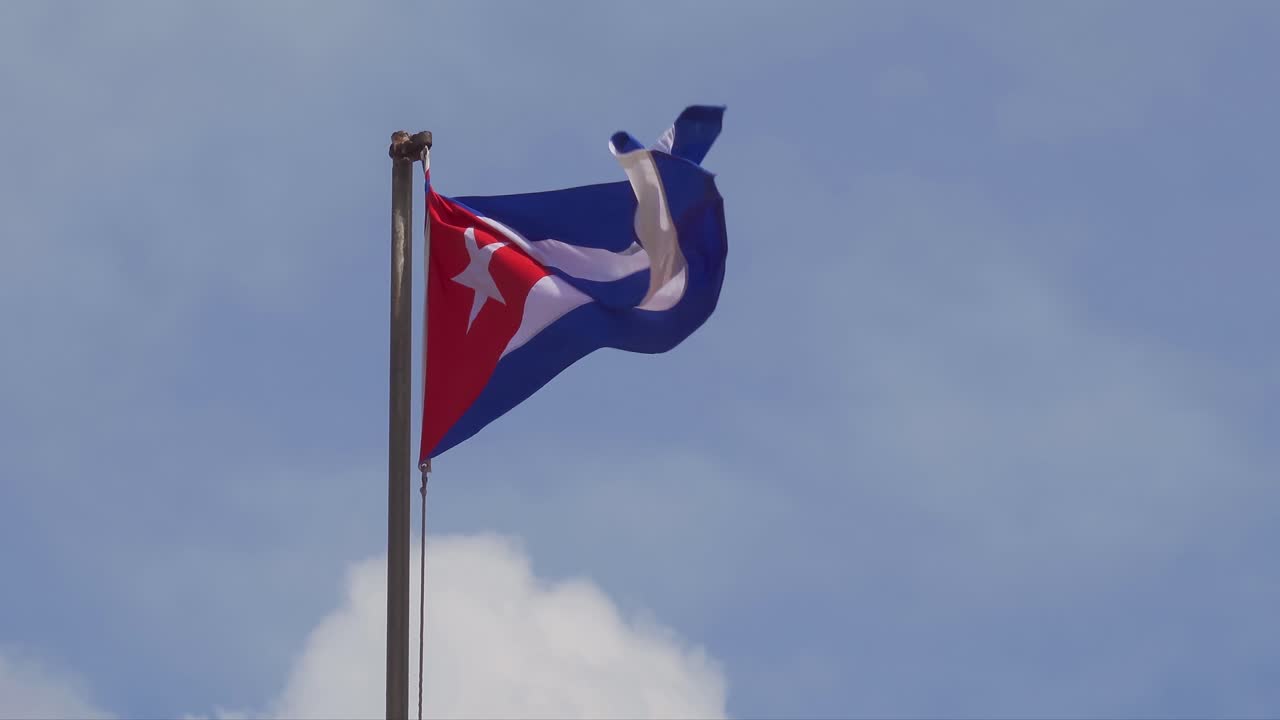 Bandiera cubana su pennone che sventola al vento, spazio per il testo a destra, fino a 4K.
