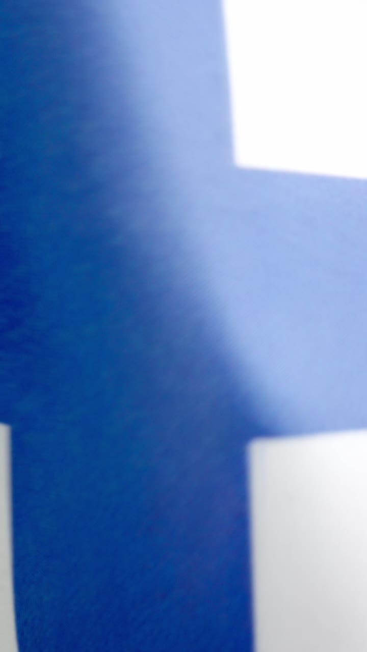 Vídeo vertical da bandeira nacional finlandesa tremulando ao vento