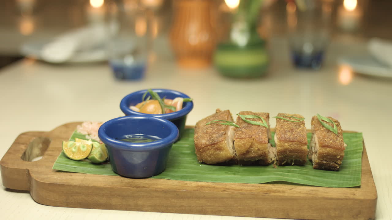 plato de lechon crujiente con un fondo de luz de vela 4k
