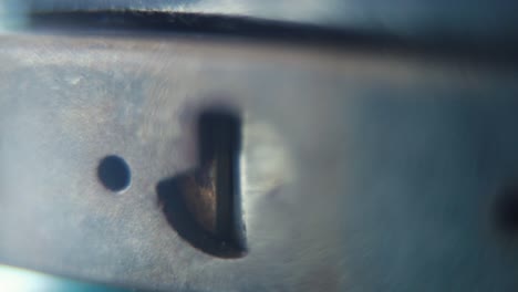 Macro-video-of-a-padlock,-shiny-steel-lock-close-up,-security-gear,-slow-motion-120fps,-full-HD,-zoom-out-smooth-movement