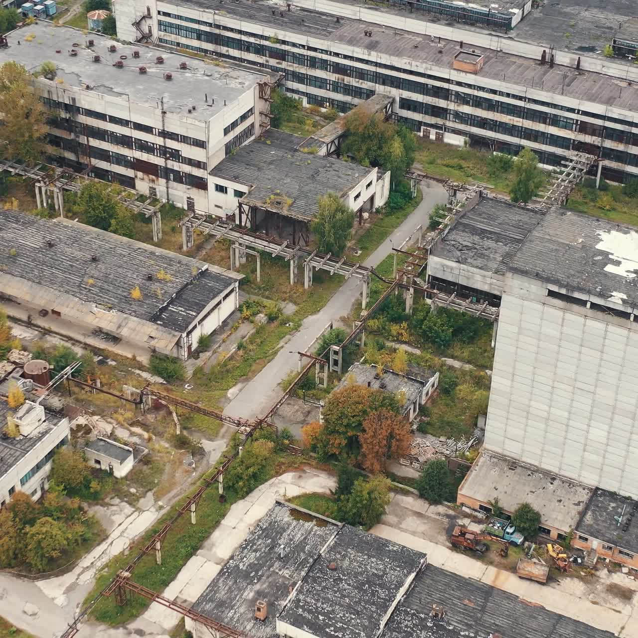 Old factory background. Exterior of industrial buildings of abandoned plant. Empty large area with with old warehouses and tall building. Aerial view