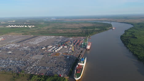 aerial view of cargo ships unloading at terminal zárate port on paraná river, argentina