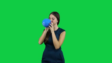 Girl-blowing-up-a-balloon-in-front-of-a-green-screen