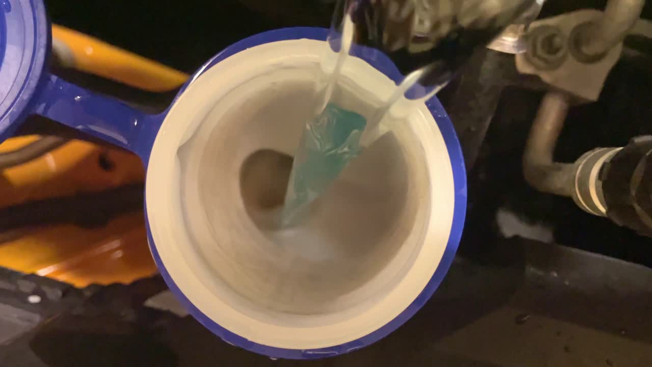 부동액이 자동차 엔진 베이에 채워지는 하향식 샷