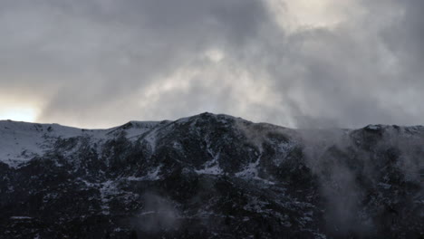 Lapso-De-Tiempo-De-La-Nube-Pasando-Por-La-Cima-De-Una-Montaña-En-Los-Alpes-Franceses,-Mientras-Se-Ve-Oscuro-Y-Malhumorado