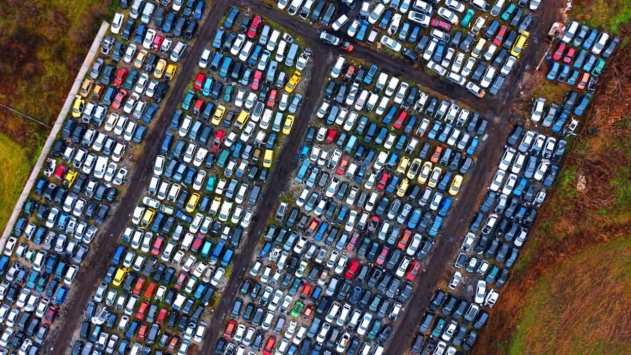 Systematic top down view of automotive salvage lot. Aerial grid pattern of scrapped vehicles arranged for dismantling and recycling at a junkyard