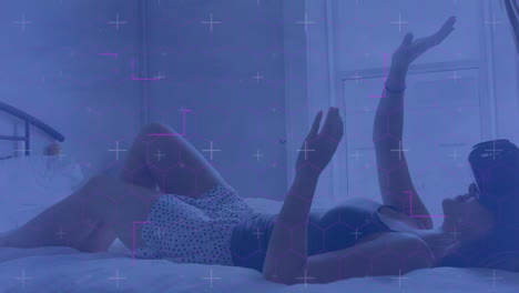 light trails against caucasian woman wearing vr headset gesturing while lying in the bed at home