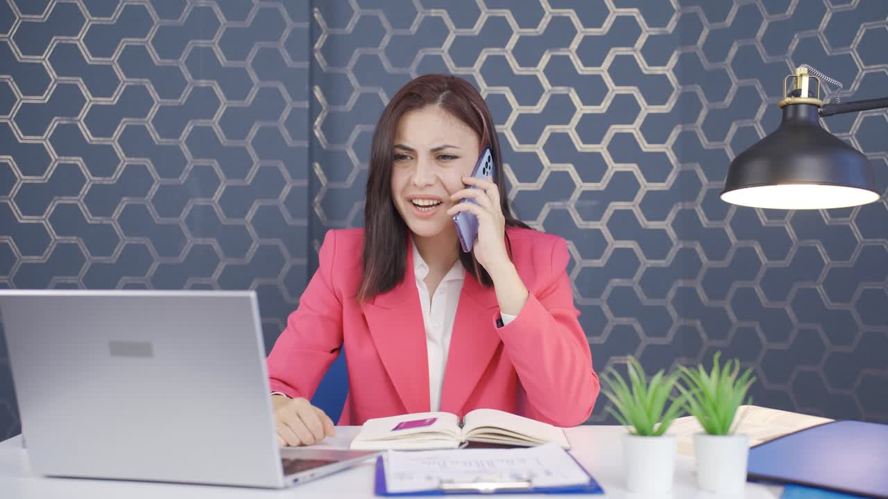 una joven mujer de negocios enojada hablando por teléfono.