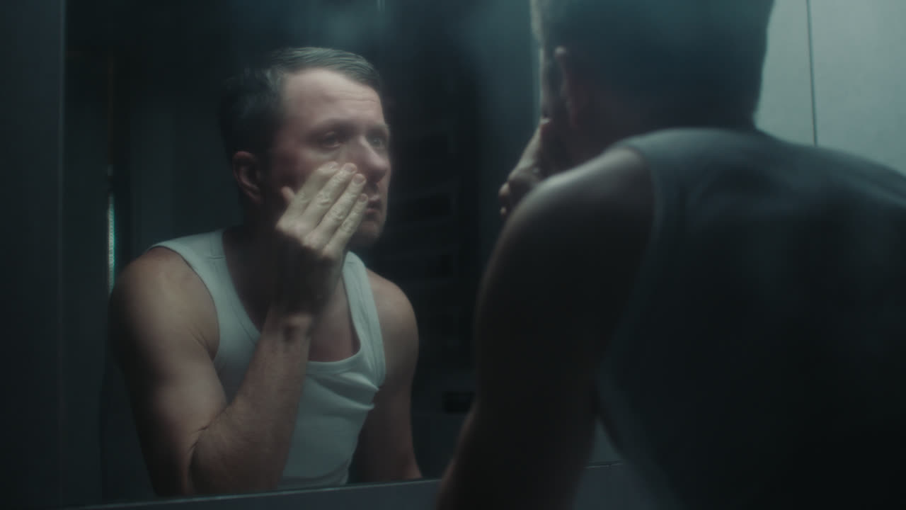 Un uomo triste in bagno durante la sua routine mattutina.