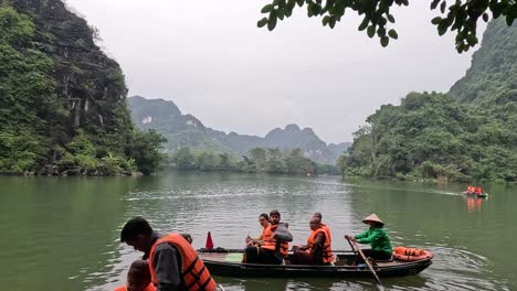 tourists rowing boats in a tranquil river setting