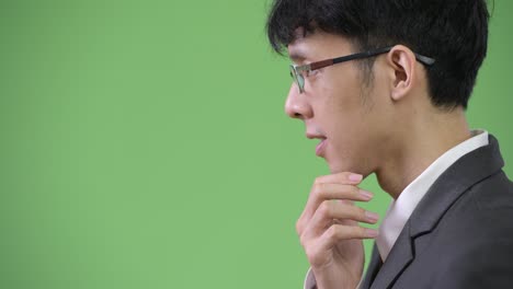 profile view of young asian businessman thinking