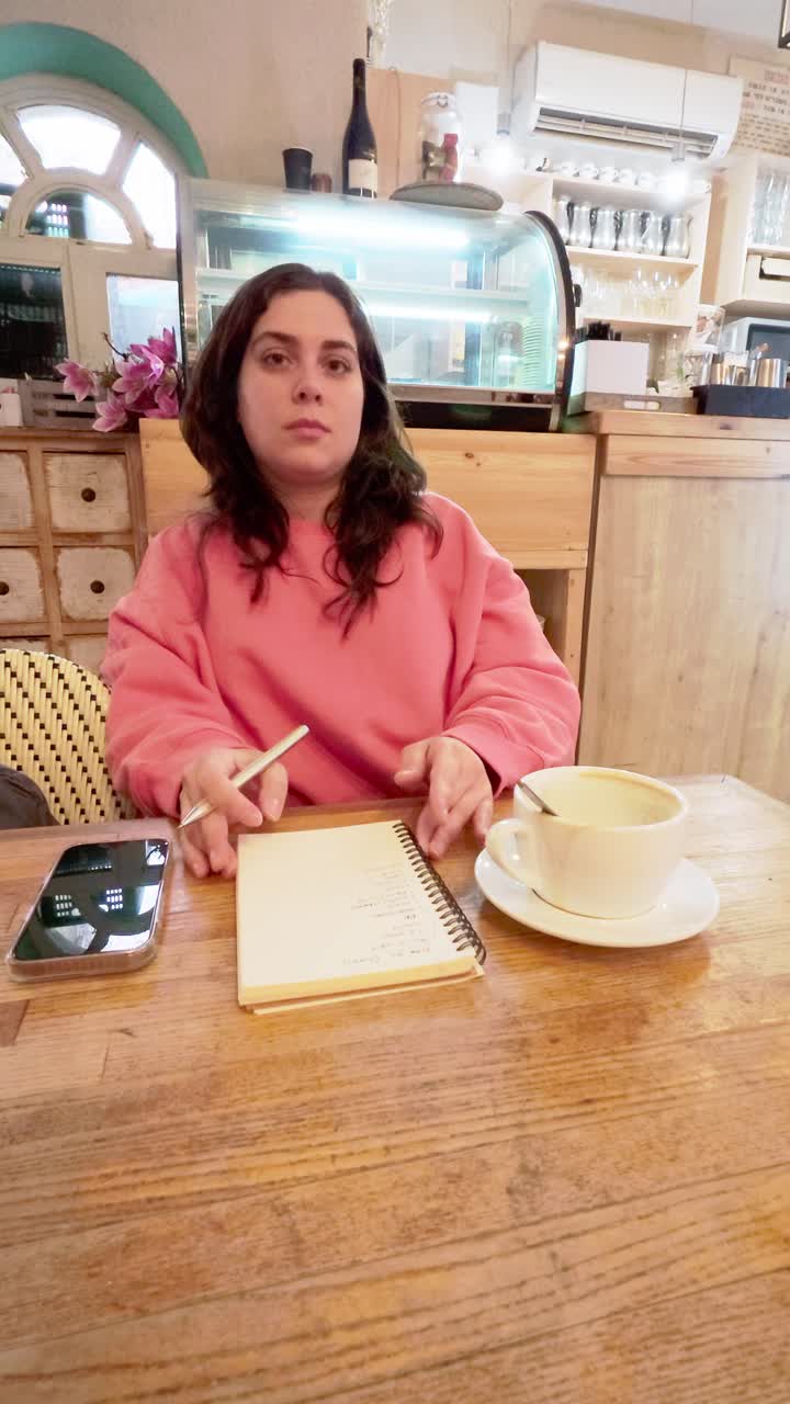 Young woman brainstorming and taking notes in cafe