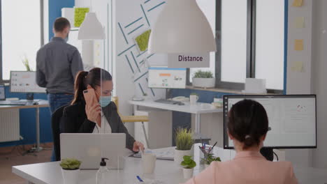 Freelancer-worker-with-protection-mask-discussing-on-phone-for-new-strategy