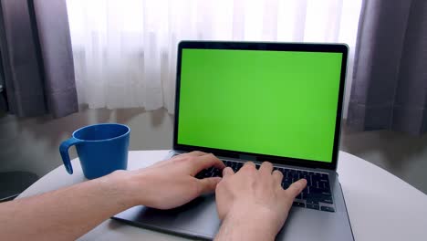 hombre escribiendo a mano teclado de portátil con tecla de croma de pantalla verde