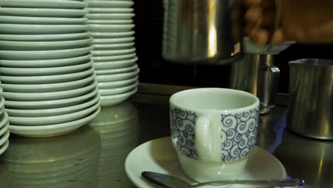 milk pouring into patterned cup, cozy coffee bar scene