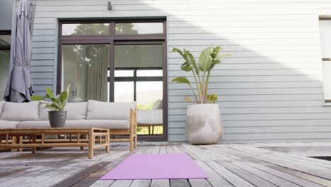 general view of terrace with sofa, plants and yoga mat on floor, slow motion