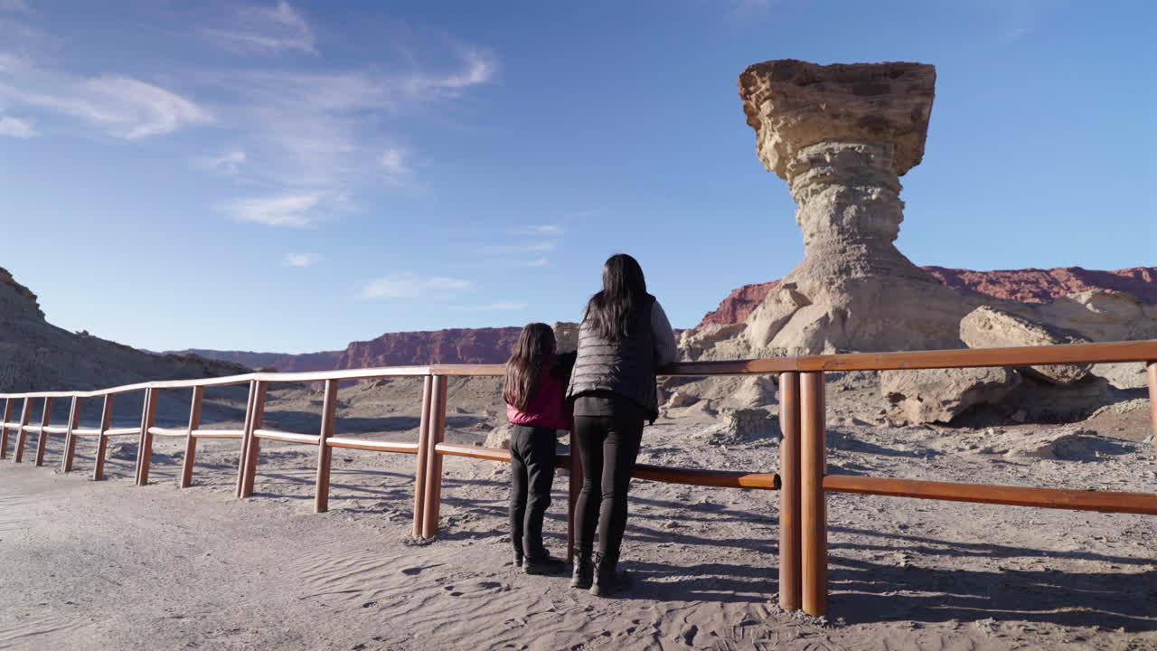 Tourist sightseeing the iconic “El Hongo” mushroom-shaped rock formation in the Moon Valley landscape, San Juan, Argentina