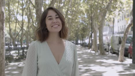 portrait of young latin woman standing on street, smiling