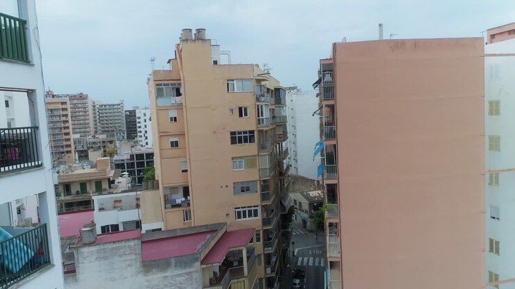 Volo in avanti di drone attraverso una stretta via residenziale in Spagna