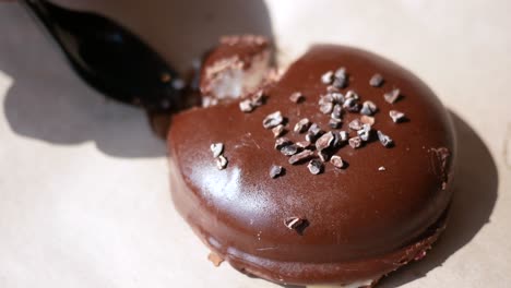 close-up of a person eating a delicious chocolate cake with cocoa nibs