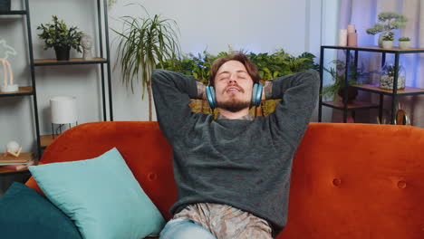 man relaxing on a couch and listening to music