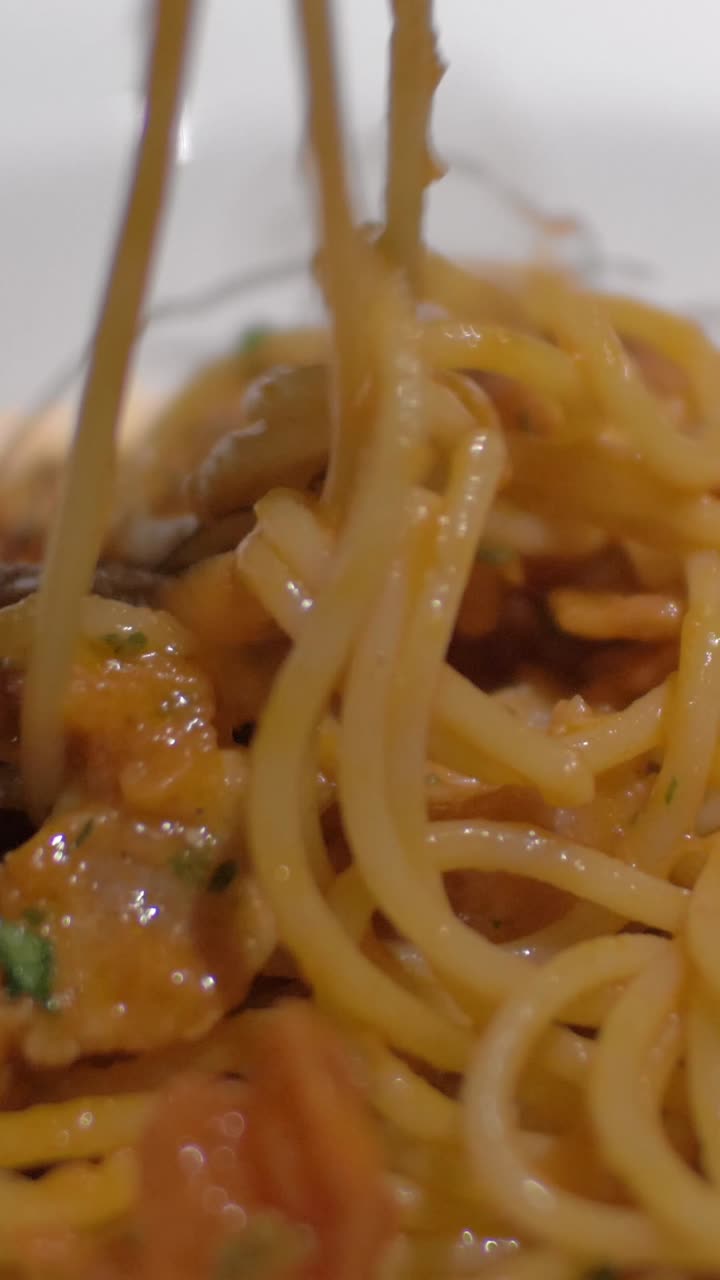 Primo piano di forchetta che avvolge spaghetti con salsa cremosa