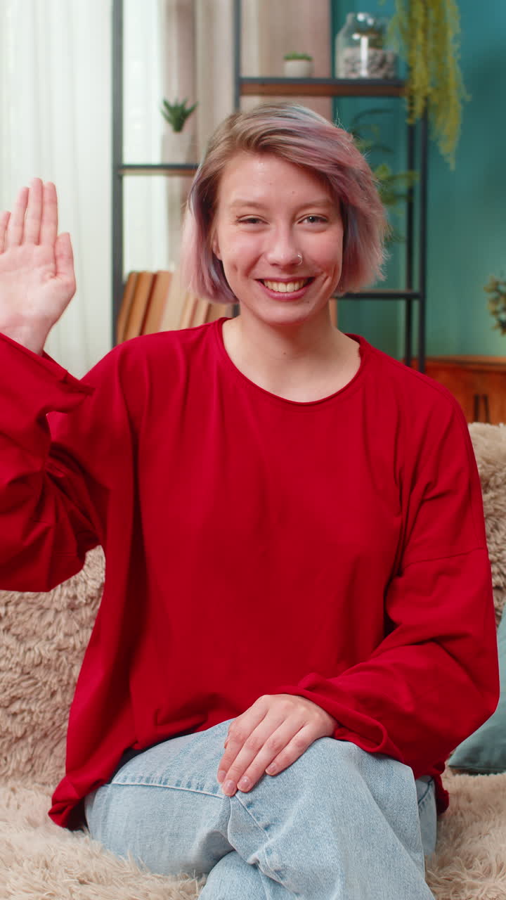 Giovane donna che saluta allegramente con la mano, esprimendo un saluto amichevole, allegro e sorridente