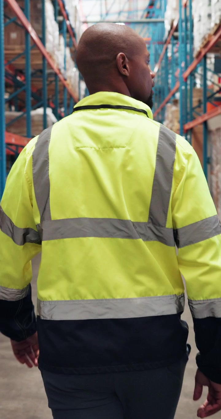 Trabajador de almacén caminando por un pasillo en un centro de distribución
