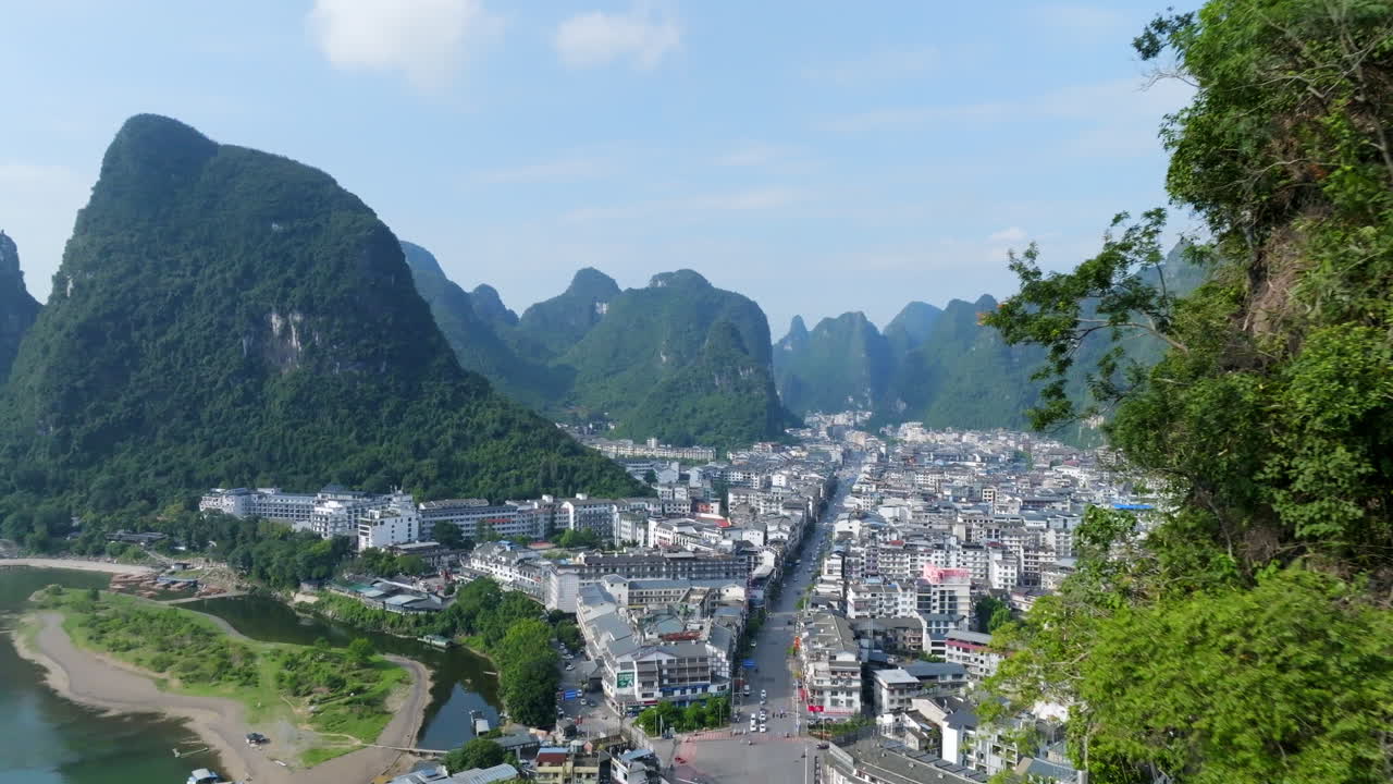 Aerial view flying close to a karst peak, revealing the Yangshuo town in China
